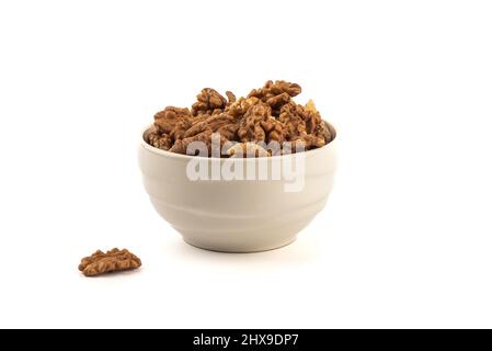 Geschälte Walnüsse in einer Keramikschale und auf weißem Hintergrund. Speicherplatz kopieren. Stockfoto