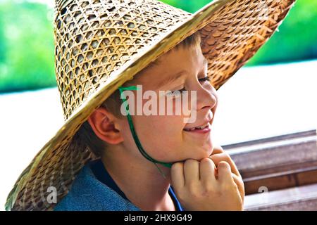 Schiffsüberfahrt, Kind trägt einen Hut aus Bambus von der Sonne in Asien geschützt werden Stockfoto