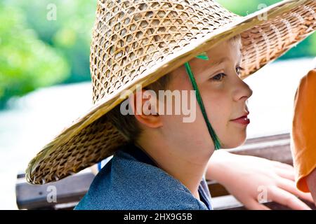 Schiffsüberfahrt, Kind trägt einen Hut aus Bambus von der Sonne in Asien geschützt werden Stockfoto