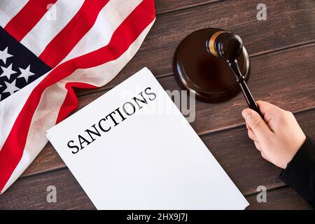 US-Sanktionen gegen Russland-Konzept. Richterhand mit Gavel, Sanktionsliste, amerikanische Flagge auf Holztisch. Stockfoto