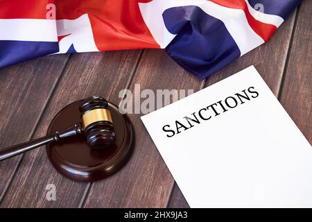 Liste der Sanktionen des Vereinigten Königreichs gegen Russland, britische Flagge und Richtergavel auf Holztisch. Stockfoto