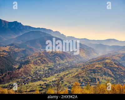 Blick von oben mit Bran Dorf in Brașov County, Siebenbürgen, Rumänien. Kleine Stadt zwischen den Karpaten. Herbstlandschaft. Stockfoto