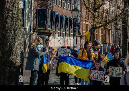 Während der Demonstration werden Demonstranten mit Plakaten zur Unterstützung der Ukraine gesehen. Das ukrainische Volk versammelte sich vor dem Repräsentantenbüro der Europäischen Kommission in Den Haag, um weiterhin gegen Putins Invasion zu protestieren und für die EU zu appellieren, ihren Beitrittsantrag zu beschleunigen, da die Niederlande den Prozess beschleunigen wollten, forderten sie die gesamte Gemeinschaft auf, sich an der Beeinflussung der offiziellen Position zu beteiligen. Ab heute werden die Staats- und Regierungschefs der EU über die Ukraineís-Anfrage diskutieren, wenn sie sich zwei Tage lang in der Nähe von Paris treffen. Stockfoto