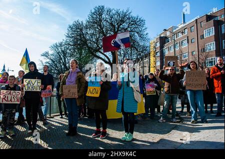 Ukrainer werden während der Demonstration Slogans gegen Putin rufen sehen. Das ukrainische Volk versammelte sich vor dem Repräsentantenbüro der Europäischen Kommission in Den Haag, um weiterhin gegen Putins Invasion zu protestieren und für die EU zu appellieren, ihren Beitrittsantrag zu beschleunigen, da die Niederlande den Prozess beschleunigen wollten, forderten sie die gesamte Gemeinschaft auf, sich an der Beeinflussung der offiziellen Position zu beteiligen. Ab heute werden die Staats- und Regierungschefs der EU über die Ukraineís-Anfrage diskutieren, wenn sie sich zwei Tage lang in der Nähe von Paris treffen. Stockfoto