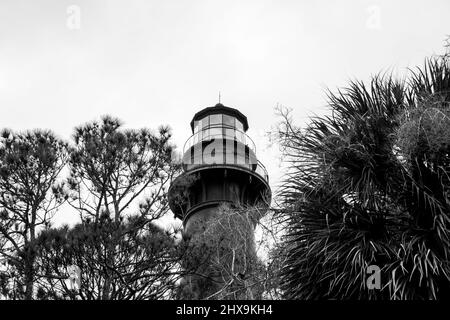 Lampe des Huntng Island Lighthouse über Bäumen in schwarz und weiß. Stockfoto