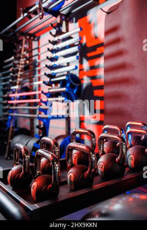 Kettlebells in verschiedenen Farben. Sportgeräte im Fitnessstudio. kettlebell für das Fitnesstraining. Ein Schuss Gewichte Reihen sich in einer Reihe im Fitnessstudio an. Stockfoto