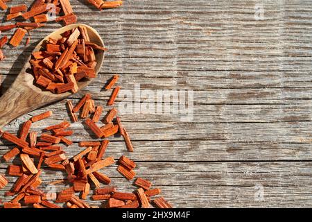 Stücke aus rotem Sandelholz auf einem Löffel auf einem rustikalen Holzhintergrund mit Kopierraum Stockfoto