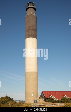 Oak Island Lighthouse am Caswell Beach, North Carolina, neben dem Keeper House. Stockfoto