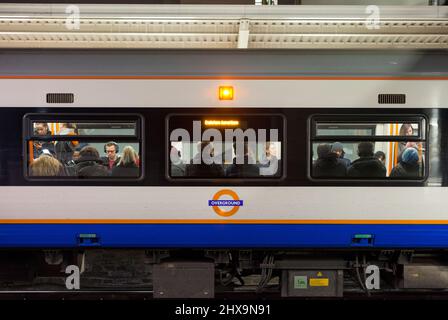 Passagiere in einem gefüllten Zug der London Overground-Klasse 378, der das Overground-Logo trägt Stockfoto