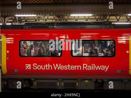 Pendler in einem überfüllten South Western Eisenbahn Zug aus London weg in Clapham Junction in der abendlichen Hauptverkehrszeit Rubrik Stockfoto