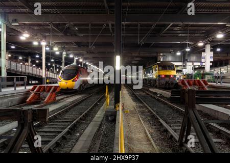 Freightliner Baureihe 90 E-Lokomotive am Bahnhof London Euston mit leerem Bestand des caledonischen Schlafzuges, Virgin Trains Pendolino (L) Stockfoto