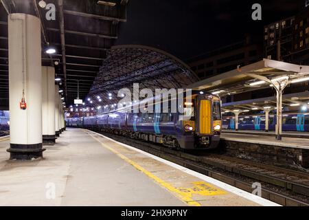 South Eastern Trains der Klasse 377 Third Rail 750v DC Electric train 377514 + 377164 London Victoria wartet auf die Abfahrt in der Nacht Stockfoto