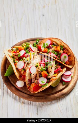 Pitacos, mexikanische Tacos mit Pita-Brot, würziges Hühnerfleisch, rote Nierenbohnen, Mais, Rettich, roter Pfeffer, Süßkartoffeln und Limette auf Holz rösten Stockfoto