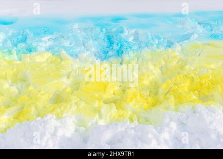 Ukrainische blaue und gelbe Flagge auf Schnee mit Sprühfarbe gemalt Stockfoto