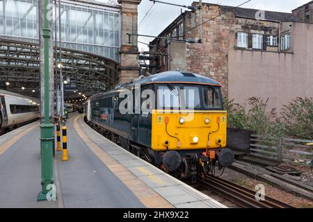 Glasgow Central Station, erhaltene elektrische Lokomotive der Klasse 86 86101, die den leeren Vorrat aus dem Nachtzug des Caledonian Sleeper aus London schleppt Stockfoto