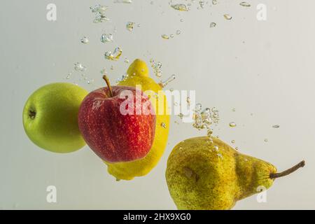 Wunderschöne Aussicht auf bunte Früchte, die im Wasser schwimmen. Stockfoto