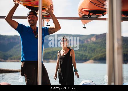 Frau und Mann, die nach einer Route einige Kajaks auf einigen Stützen platzieren. Stockfoto