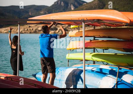 Arbeiter, die nach einer Route einige Kajaks auf einigen Stützen platzieren. Stockfoto