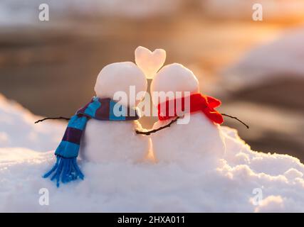 Niedlichen Schneemann Paar in der Liebe mit Schnee Herz zwischen ihnen. Stockfoto