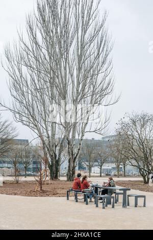 Straßburg, Frankreich - 21. März 2015: Studenten machen eine Pause beim Essen am Stahl-Outdoor-Möbeltisch auf dem Campus der Universität Straßburg Universite de Strasbourg Stockfoto