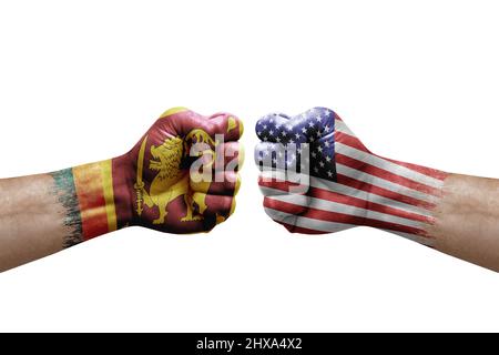 Zwei Hände schlagen sich gegenseitig auf weißem Hintergrund zu. Länderflaggen bemalten Fäuste, Konfliktkrisenkonzept zwischen sri lanka und den usa Stockfoto
