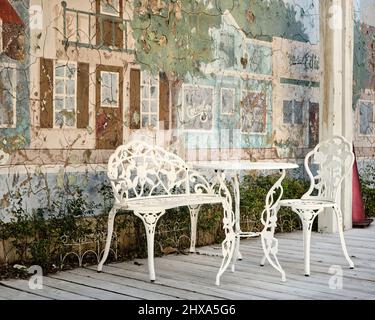 Weißer schmiedeeiserner Tisch und Stühle auf einer Terrasse oder Terrasse in Fairhope Alabama, USA. Stockfoto