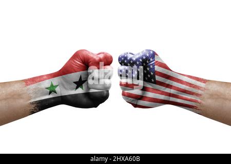 Zwei Hände schlagen sich gegenseitig auf weißem Hintergrund zu. Länderflaggen bemalten Fäuste, Konfliktkrisenkonzept zwischen syrien und den usa Stockfoto