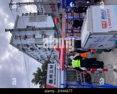SHANGHAI, CHINA - 11. MÄRZ 2022 - Sicherheitskräfte sind am 11. März 2022 in Shanghai, China, in einer geschlossenen Wohnanlage in der neuen Region Pudong im Einsatz. Stockfoto