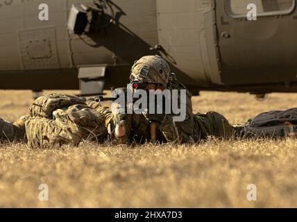 Ein US-Soldat, der Charlie Company, 1. Squadron, 2. Cavalry Regiment, zugewiesen wurde, probt während des Sabre Strike 22 im Militärtrainingsgebiet Lest, Slowakei, 2. März 2022 Infill- und Ausfüllverfahren eines UH60M Blackhawks. Sabre Strike 22 ist eine multinationale Übung vom 28. Februar bis zum 18. März 2022, die die Teilnahme von 13 NATO-Alliierten und Partnernationen umfasst. Die Übung soll die kollektiven Fähigkeiten der NATO zeigen, unter strengen Bedingungen zu operieren, und zeigen, dass wir gemeinsam stärker sind. (USA Armee-Foto von SPC. Fallon Lewis) Stockfoto