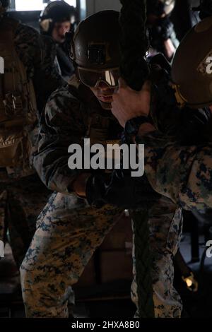 U.S. Marine Corps Lance CPL. Ryan Helm, ein Maschinengewehrschütze mit Echo Company, 2. Bataillon, 6. Marineinfanteristen, sprang zum schnellen Seil von einem CH-53E Superhengst an Bord des Marine Corps Base Camp Lejeune, North Carolina, 24. Februar 2022. Echo Co. Führte Schnellseiltraining durch, um sich für luftgestützte Einführoperationen zu zertifizieren, um einen bevorstehenden Einsatz vorzubereiten. (USA Marine Corps Foto von CPL. Henry Rodriguez) Stockfoto