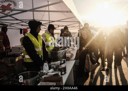 Lviv, Ukraine. 10. März 2022. Freiwillige verteilen Lebensmittel und andere Gegenstände an Flüchtlinge, die am Lviv Hauptbahnhof in Lviv ankommen. Seit Beginn der russischen Invasion in der Ukraine sind rund zwei Millionen Flüchtlinge aus ihren Häusern geflohen und sind nach Polen und in andere Nachbarländer gekommen, von denen viele durch die westliche Stadt Lviv zum Ziel kamen. (Foto: Matthew Hatcher/SOPA Images/Sipa USA) Quelle: SIPA USA/Alamy Live News Stockfoto