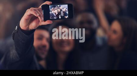 Ein letztes Selfie für das Jahr. Ausgeschnittene Aufnahme einer Gruppe junger Freunde, die Selfies beim gemeinsamen Tanzen in einem Nachtclub machen. Stockfoto