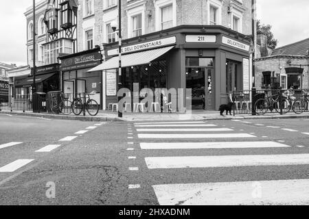 London, Großbritannien - August 20 2015; typisch traditionelles London, Straßenszene mit Bogen, Fußgängerüberweg zum Deli über die Kreuzung. Stockfoto