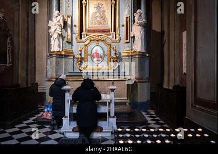 Lviv, Ukraine. 10. März 2022. Man sieht die Menschen im Inneren der Kathedrale beten. Der polnische Kardinal Konrad Krajewski, der päpstliche Almoner in der Ukraine, nahm an dem interreligiösen Gottesdienst in der Kathedrale zur Himmelfahrt der seligen Jungfrau Maria (Lviv Metropolitan Basilica) in Lviv in Anwesenheit von Vertretern des Panukrainischen Rates der Kirchen und verschiedener Religionsgemeinschaften Teil. (Foto von Valeria Ferraro/SOPA Images/Sipa USA) Quelle: SIPA USA/Alamy Live News Stockfoto