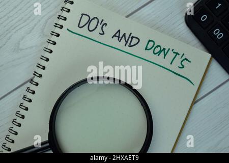 Do's und Don't's schreiben auf ein Buch isoliert auf Holztisch. Stockfoto