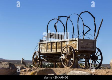 Rahmen der isolierten Old Vintage Wooden Wild West Pioneer Stage Coach Wagon Wheel Replica gegen die blaue Skyline in Utah, USA Stockfoto