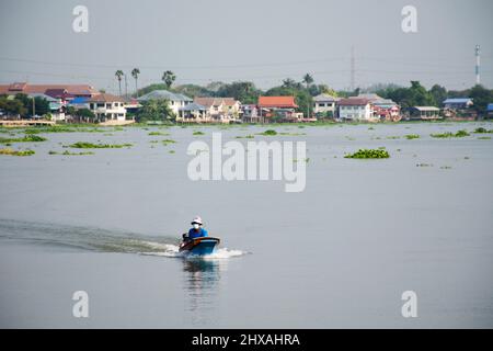 Lebensstil der thailänder am chaopraya-Fluss mit Menschen, die auf einem langen Boot reiten und das landschaftliche Fischerdorf am Sam Khok-Wasserf bewundern Stockfoto