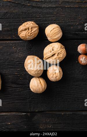 Ganze organische Walnüsse, auf schwarzem Holztischhintergrund, Draufsicht flach liegend, mit Platz für Text Stockfoto