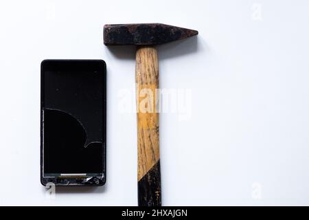 Gebrochene berühren Handy auf dem weißen Hintergrund und Hammer Stockfoto
