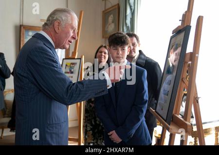 Der Prinz von Wales trifft auf Alfie Craddock, 12 Jahre alt, einen nationalen Gewinner des Briefmarkenwettbewerbs „Heroes of the Pandemic“ von Royal Mail, während er die Gewinnerentwürfe im Clarence House in London ansiegt. Bilddatum: Donnerstag, 10. März 2022. Stockfoto