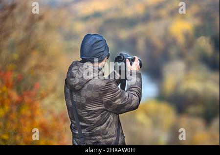 Rückansicht von Young Photographer macht Bilder von Herbstlandschaft, Nahaufnahme Stockfoto