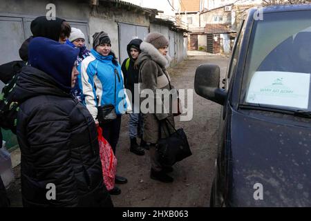 ODESA, UKRAINE - 10. MÄRZ 2022 - Menschen, die vor der russischen Invasion fliehen, sind in der Nähe eines kostenlosen Evakuierungsbusses versammelt, der sie zur Grenze bringen soll Stockfoto