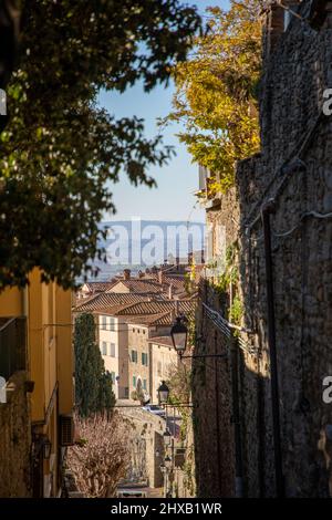 Durch die engen Gassen von Cortona in seinem Dorf zwischen den Häusern und Bäumen. Stockfoto