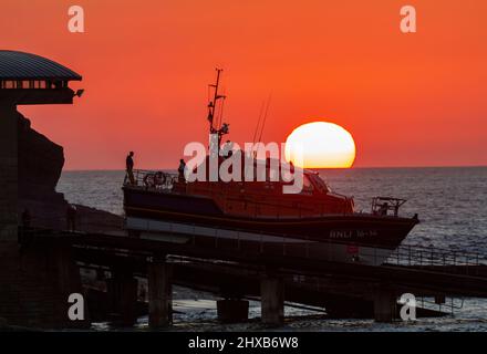 Sennen Rettungsboot startet bei Sonnenuntergang auf einem Training am Abend Stockfoto