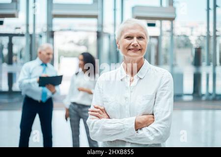 Eine reife, selbstbewusste Geschäftsfrau, die in der Halle des Business Centers steht. Stockfoto