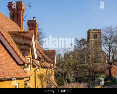 Straßenszene im Winter im hübschen Dorf Great Brington, Northamptonshire, Großbritannien; Kirche St. Mary im Hintergrund. Stockfoto