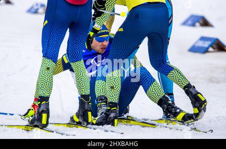 Zhangjiakou, China. 11. März 2022. Paralympics, para Nordic Ski, Biathlon, 12,5 km, Sehbehindert, Oleksandr Kazik aus der Ukraine gewinnt das 12,5-km-Rennen und wird im Ziel von Teamkollegen unterstützt. Quelle: Jens Büttner/dpa-Zentralbild/dpa/Alamy Live News Stockfoto