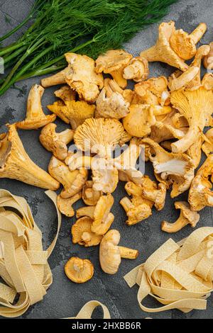 Rohe Tagliatelle mit Pfifferlinge Pilze Zutaten Set, auf grauem Stein Tisch Hintergrund, Draufsicht flach legen Stockfoto
