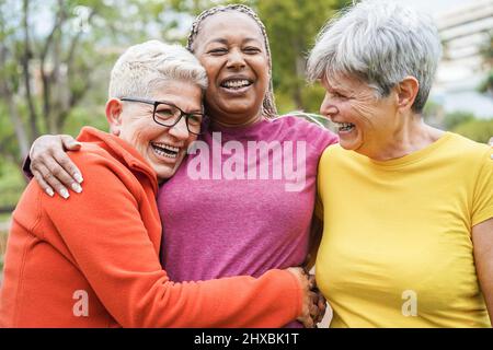 Multirassische ältere Frauen, die nach dem Sport-Workout im Freien Spaß zusammen haben - Konzentrieren Sie sich auf das linke weibliche Gesicht Stockfoto