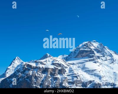 Gleitschirmflieger vor den berühmten Schweizer Bergen Eiger, Mönch und Jungfrau Stockfoto